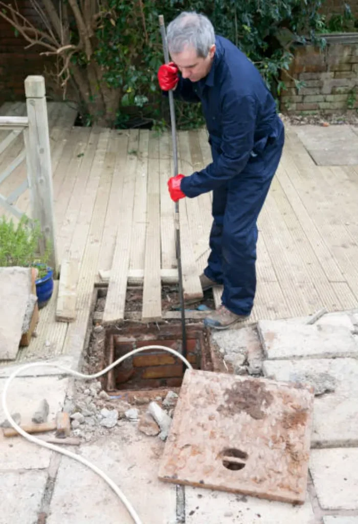 Drain cleaning contractor clearing clogged pipe system